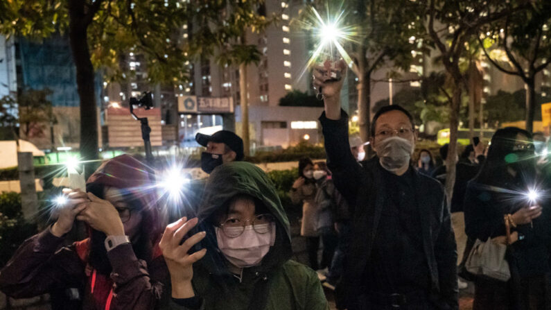 Des supporters brandissent la lumière de leur téléphone portable en chantant devant le tribunal de première instance de West Kowloon, au quatrième jour de l'audience de libération sous caution de 47 militants de l'opposition accusés d'avoir violé la loi sur la sécurité nationale de la ville, le 4 mars 2021 à Hong Kong, en Chine. (Photo : Anthony Kwan/Getty Images)