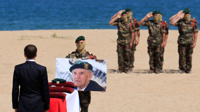 Emmanuel Macron honore le cercueil recouvert de drapeaux de Léon Gautier, vétéran français de la Seconde Guerre mondiale. (Photo PASCAL ROSSIGNOL/POOL/AFP via Getty Images