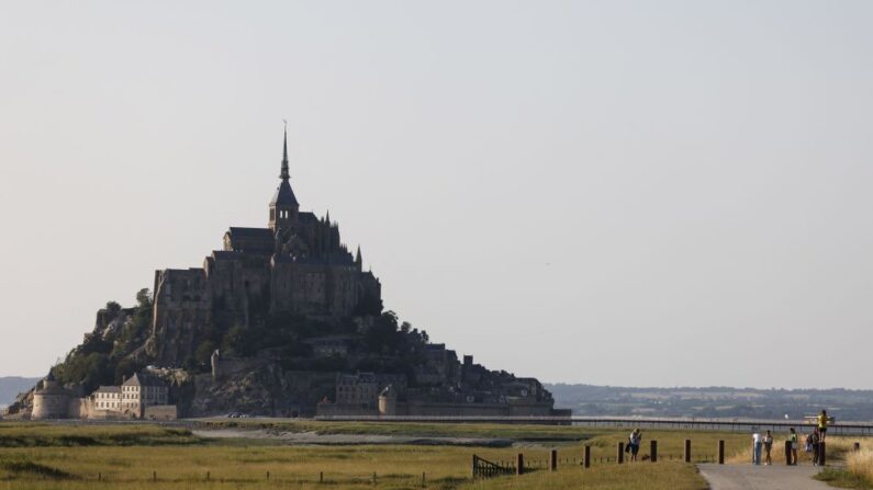 Des visiteurs marchent vers le Mont-Saint-Michel, Normandie, le 7 juillet 2023. (Crédit photo LUDOVIC MARIN/AFP via Getty Images)