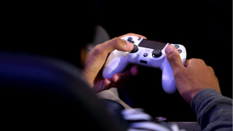 Un joueur tenant une manette de PS4 à Londres le 28 mars 2019. (Alex Pantling/Getty Images)