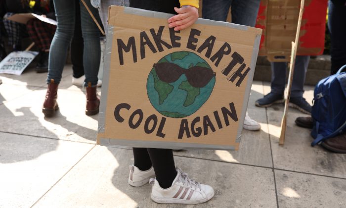 Un manifestant tient un panneau « Make Earth Cool Again » (Rafraîchissez à nouveau la Terre) lors de la marche étudiante YouthStrike4Climate organisée à Londres, le 12 avril 2019. (Dan Kitwood/Getty Images)