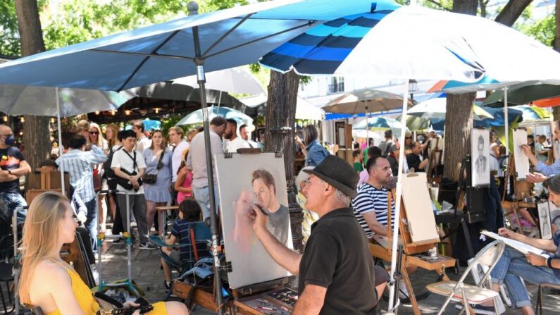 Des portraitistes à l'oeuvre, dans le quartier de Montmartre, le10 juillet 2022. (Crédit photo ALAIN JOCARD/AFP via Getty Images)