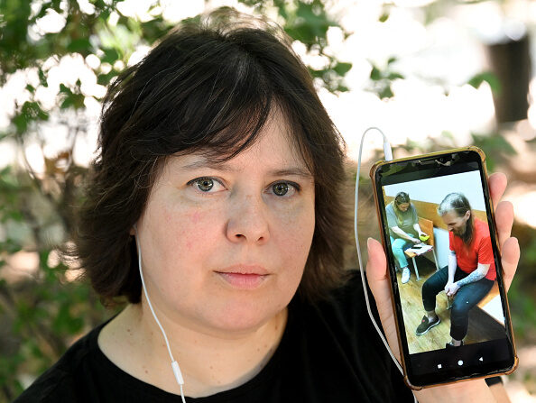 Tatiana Sporycheva, militante des droits de l'homme, montre un clip vidéo d'Anatoly Berezikov lors de sa comparution devant le tribunal, le 24 juillet 2023. (Photo VANO SHLAMOV/AFP via Getty Images)