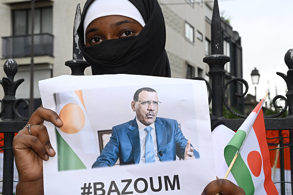 Une femme tient l'image du président nigérien Mohamed Bazoum, détenu par des putschistes avec sa famille dans sa résidence officielle de Niamey depuis le 26 juillet. (Photo STEFANO RELLANDINI/AFP via Getty Images)