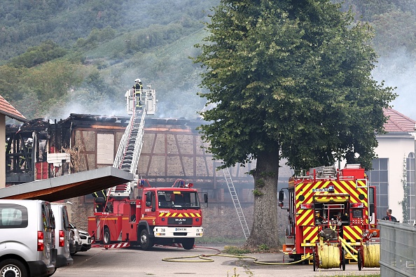 Des pompiers s'efforcent d'éteindre un incendie qui s'est déclaré dans un foyer pour personnes handicapées à Wintzenheim, près de Colmar, le 9 août 2023. (Photo ANNE-CHRISTINE POUJOULAT/AFP via Getty Images)