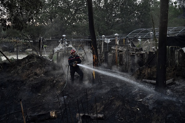 Un pompier éteint le feu après l'incendie qui a ravagé la commune de Saint-André dans les Pyrénées-Orientales, le 15 août 2023. (Photo RAYMOND ROIG/AFP via Getty Images)