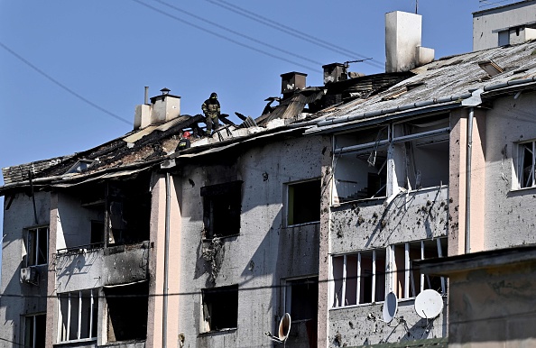 Un secouriste examine le toit d'un immeuble résidentiel endommagé après un tir de missile sur la ville de Lviv, en Ukraine. (Photo GENYA SAVILOV/AFP via Getty Images)