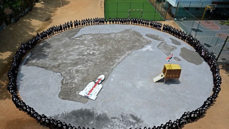 Des étudiants forment un cercle autour d'une réplique du vaisseau spatial Chandrayaan-3 à Chennai, le 22 août 2023. (Photo R.SATISH BABU/AFP via Getty Images)