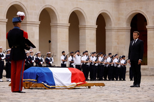 Le président Emmanuel Macron honore le cercueil drapé lors d'un hommage national à Jean-Louis Georgelin, ancien chef de l'armée française chargé de restaurer l'emblématique cathédrale Notre-Dame de Paris, à l'hôtel des Invalides à Paris, le 25 août 2023. (Photo CHRISTIAN HARTMANN/POOL/AFP via Getty Images)