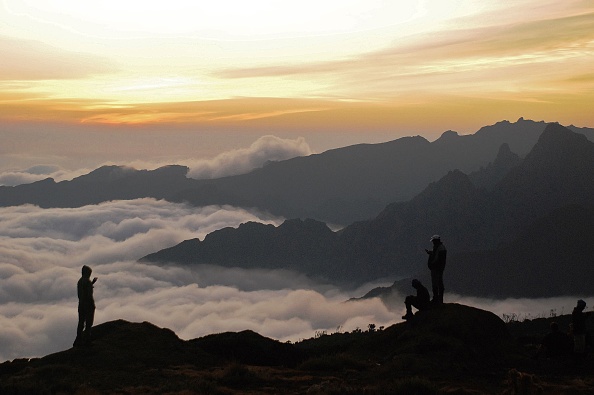 Image d'illustration : des alpinistes observent le coucher du soleil lors d'une ascension au Kilimandjaro en Tanzanie. (PETER MARTELL/AFP via Getty Images)