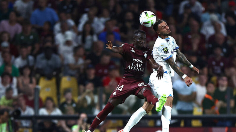 Cheikh Tidiane Sabaly (à.g) de Metz se bat pour le ballon avec le défenseur de Marseille Jonathan Clauss (à.d) lors du match de football de L1 française entre le FC Metz et l'Olympique de Marseille (OM), le 18 août 2023. (Photo : SEBASTIEN BOZON/AFP via Getty Images)