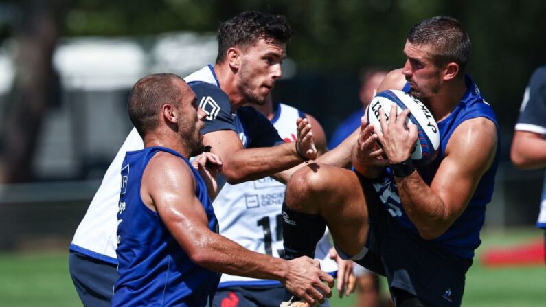 Thomas Ramos (à.d) tient le ballon lors d'une séance d'entraînement du XV de France le 23 août 2023. (Photo : ANNE-CHRISTINE POUJOULAT/AFP via Getty Images)