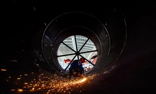 Un ouvrier soude des pièces de matériaux de construction dans une usine à Nantong, dans la province de Jiangsu, en Chine, le 16 mai 2023. (STR/AFP via Getty Images)