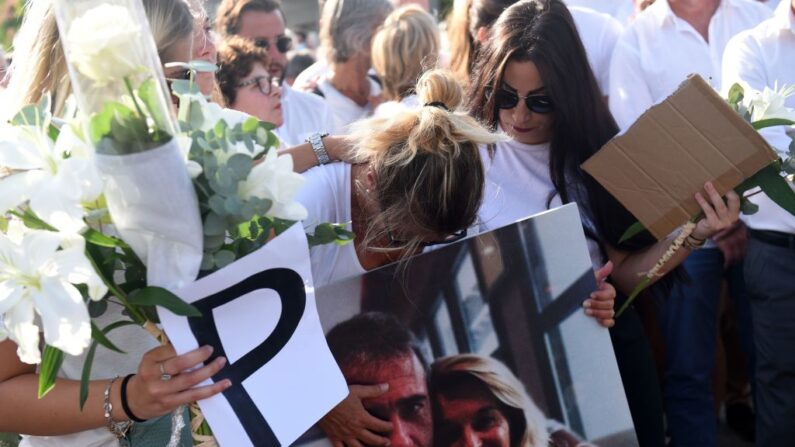 Véronique Monguillot (C), épouse du chauffeur de bus Philippe Monguillot, tient une photo de son mari lors d'une marche blanche à Bayonne, le 8 juillet 2020. (Photo: GAIZKA IROZ/AFP via Getty Images)