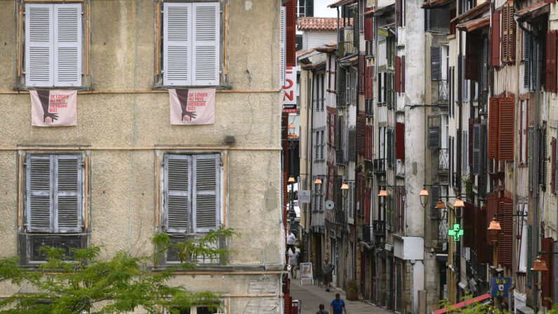 Une banderole sur laquelle on peut lire « Se loger à la campagne - Herrian bizi », est accrochée aux fenêtres d'un appartement à Bayonne, le 19 juin 2023. Au Pays basque, les prix élevés et la rareté des biens immobiliers rendent difficile l'installation de structures sociales, qui ont besoin de loyers bas pour compenser leur faible rentabilité. (Photo : GAIZKA 
IROZ/AFP via Getty Images)