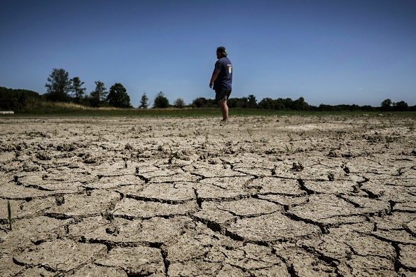 Un pisciculteur examine ce qui reste de son étang touché par la sécheresse, le 11 août 2023 près de Joyeux dans le plateau de la Dombes. (Photo JEFF PACHOUD/AFP via Getty Images)