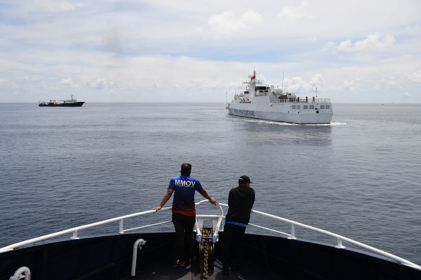 Le personnel du navire Datu Bankaw du Bureau philippin de la pêche et des ressources aquatiques (BFAR) surveille un navire des garde-côtes chinois près de l'entrée du Scarborough Shoal, le 22 septembre 2023. (Photo TED ALJIBE/AFP via Getty Images)