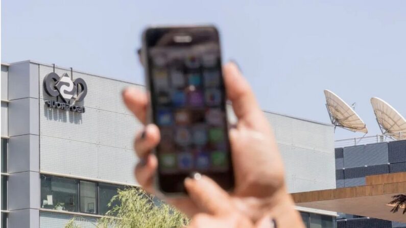 Une femme utilise son iPhone devant le bâtiment abritant le groupe israélien NSO, à Herzliya, près de Tel Aviv, le 28 août 2016. (Jack Guez/AFP via Getty Images)