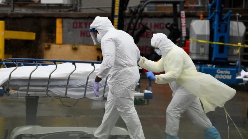 Le personnel médical transporte un patient décédé vers un camion réfrigéré servant de morgue de fortune, au Brooklyn Hospital Center de New York, le 9 avril 2020. (Angela Weiss/AFP via Getty Images)