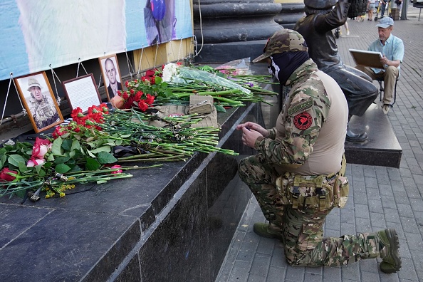 Un membre du groupe de Wagner rend hommage à Evguéni Prigojine (à g.) et à Dmitri Utkin, un personnage de l'ombre qui a géré les opérations de Wagner, au mémorial improvisé à Rostov-sur-le-Don, le 24 août 2023. (Photo STRINGER/AFP via Getty Images)