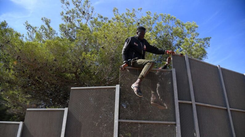 Des migrants traversent la clôture pour sortir du centre opérationnel appelé "Hotspot" sur l'île italienne de Lampedusa, le 14 septembre 2023. (Photo: ALESSANDRO SERRANO/AFP via Getty Images)