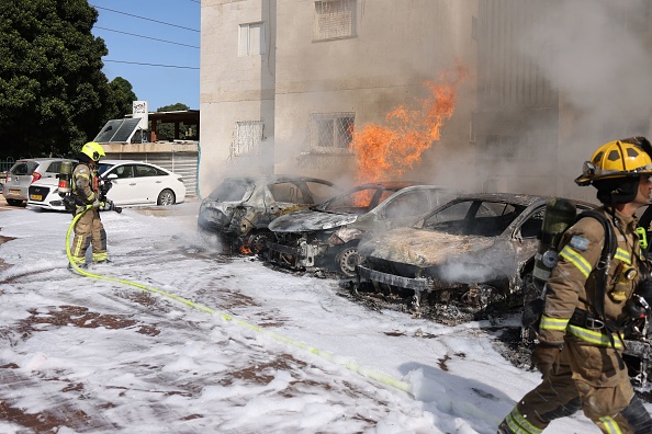 Des équipes de pompiers israéliens éteignent le feu à l'extérieur d'un immeuble résidentiel, le 07 octobre 2023. (Photo AHMAD GHARABLI/AFP via Getty Images)