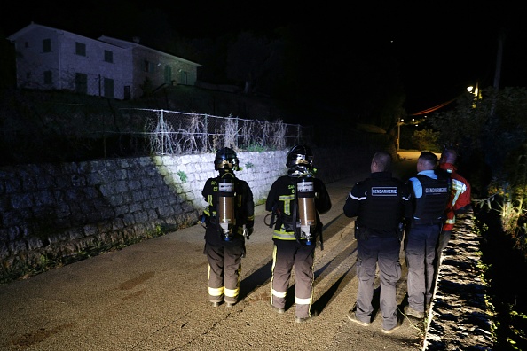 Pompiers et gendarmes observent une maison visée par une explosion et partiellement détruite par l'incendie à Vico le 8 octobre 2023 en Corse. (Photo PASCAL POCHARD-CASABIANCA/AFP via Getty Images)