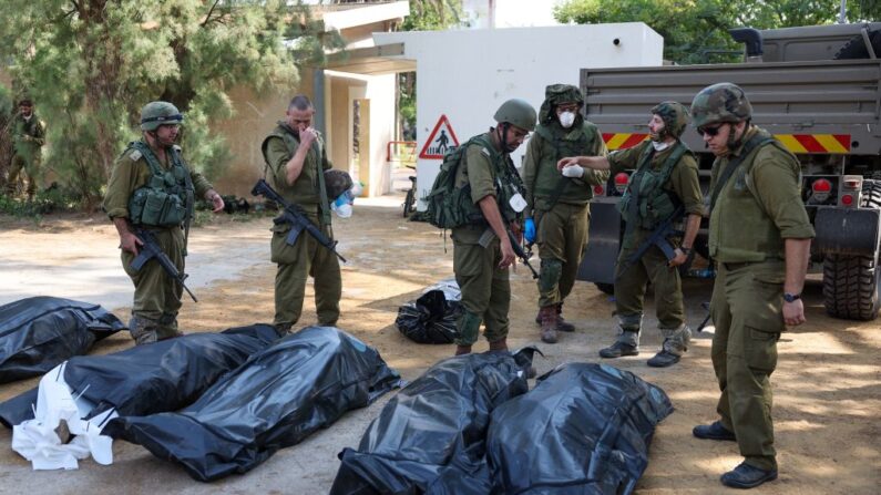 Des soldats israéliens se préparent à retirer les corps de leurs compatriotes, tués au kibboutz de Kfar Aza, au sud d'Israël, à la frontière de la bande de Gaza, le 10 octobre 2023. (Photo JACK GUEZ/AFP via Getty Images)