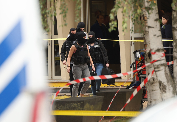 Des enquêteurs de la police sortent du lycée Gambetta à Arras le 13 octobre 2023/ (Photo FRANCOIS LO PRESTI/AFP via Getty Images)