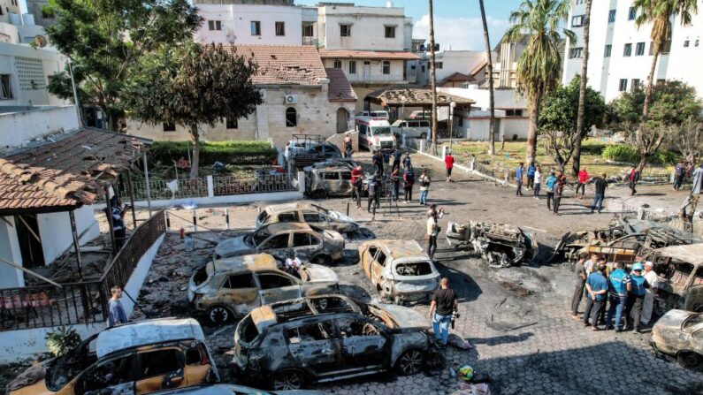 Cette vue aérienne montre des personnes debout devant des bâtiments détruits sur le site de l'hôpital Ahli Arab dans le centre de Gaza, le 18 octobre 2023, à la suite d'une attaque nocturne. (Photo SHADI AL-TABATIBI/AFP via Getty Images)