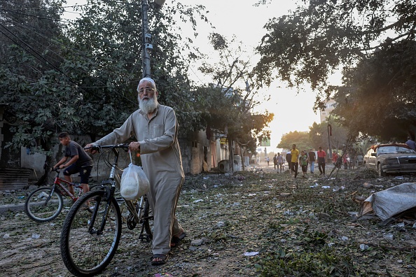 Un Palestinien porte du pain alors qu'il marche sur des débris après les frappes israéliennes sur le camp de réfugiés de Rafah dans la bande de Gaza, le 25 octobre 2023. (Photo MOHAMMED ABED/AFP via Getty Images)