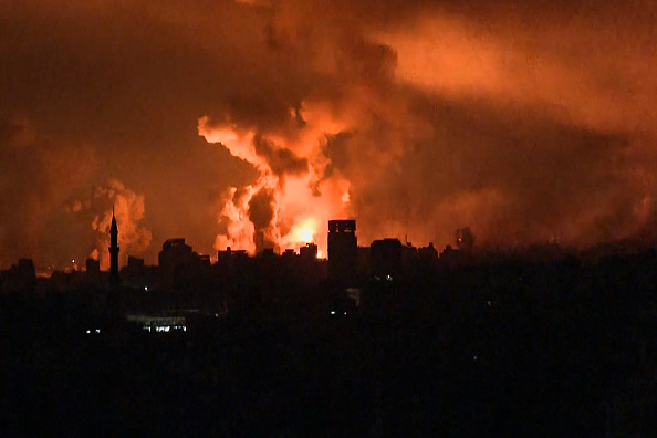 Des boules de feu et de la fumée s'élevant au-dessus de la ville de Gaza lors d'une frappe israélienne le 27 octobre 2023. (Photo YOUSEF HASSOUNA/AFP via Getty Images)