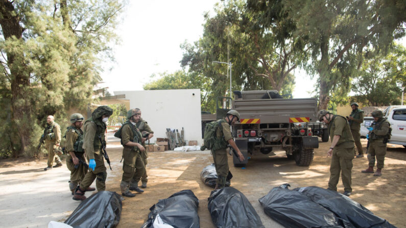 Des soldats israéliens enlèvent les corps des civils qui ont été tués lors de l'attaque lancée par des militants palestiniens sur ce kibboutz près de la frontière avec Gaza, le 10 octobre 2023 à Kfar Aza, en Israël. (Photo Amir Levy/Getty Images) 