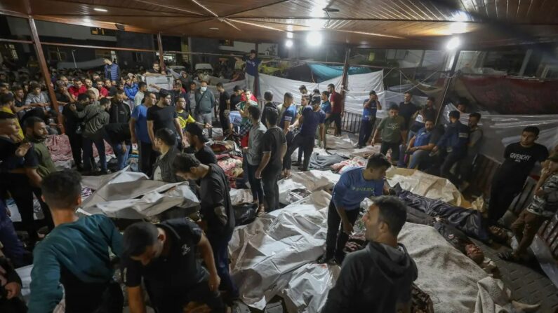 Des personnes se rassemblent autour des corps des Palestiniens tués dans une explosion à l'hôpital Ahli Arab dans le centre de Gaza après avoir été transporté à l'hôpital Al-Shifa, le 17 octobre 2023. (Dawood Nemer/AFP via Getty Images)