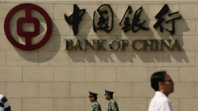 Des personnes passent devant une succursale de la Banque de Chine à Pékin, le 11 septembre 2009. (Peter Parks/AFP via Getty Images)