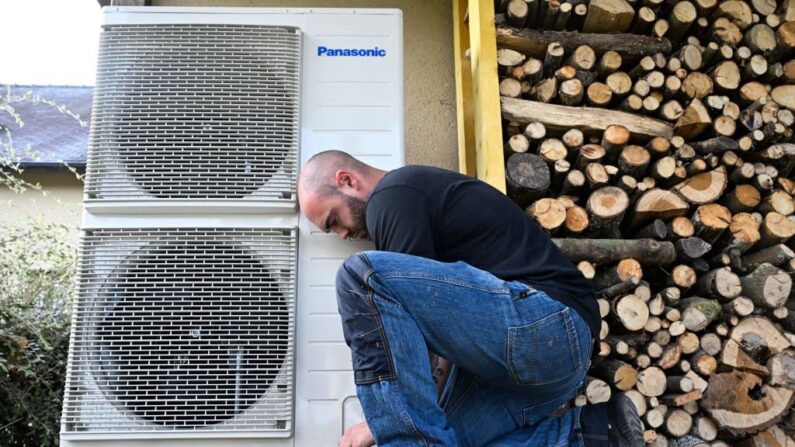 Un ouvrier installe une pompe à chaleur dans une maison privée à Saint-Didier, en Ille-et-Vilaine, le 2 octobre 2023. (Crédit photo DAMIEN MEYER/AFP via Getty Images)