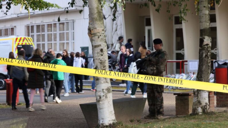 Dans le cadre de l'opération "Sentinelle", un militaire monte la garde derrière une zone bouclée du lycée Gambetta lors de son évacuation après une alerte à la bombe à Arras, le 16 octobre 2023. (Photo DENIS CHARLET/AFP via Getty Images)