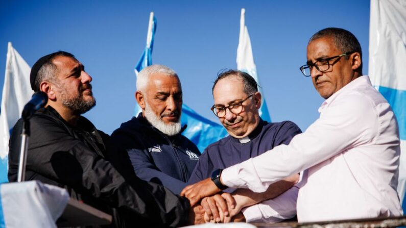 Le rabbin Haim Bendao (à g.), Rachid Zeroual, dirigeant d'un fan club de l'Olympique de Marseille (deuxième à g.), le prêtre Olivier Spinosa (deuxième à dr.), et l'imam Hassan Rajii (à dr.), devant la basilique Notre-Dame de la Garde, à Marseille, le 24 octobre 2023. (Photo CLEMENT MAHOUDEAU/AFP via Getty Images)