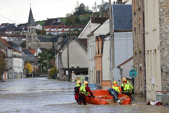 Des pompiers marchent dans une rue inondée lors d'une opération de sauvetage à Isques, près de Boulogne-sur-Mer, le 7 novembre 2023. (Photo DENIS CHARLET/AFP via Getty Images)