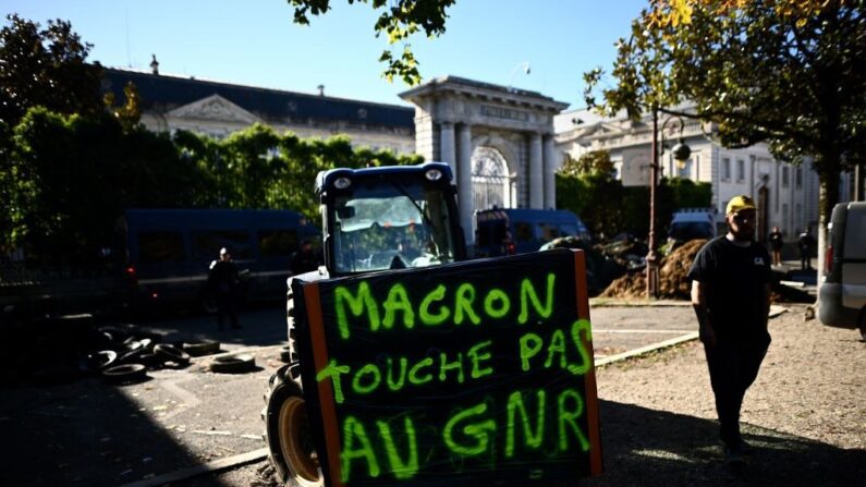 Un agriculteur conduit un tracteur portant une pancarte "Macron, touche pas au GNR" devant la préfecture d'Agen lors d'un rassemblement organisé par le syndicat agricole Coordination Rurale 47 dénonçant le projet du gouvernement de mettre fin aux subventions fiscales pour le gazole non routier, le 8 novembre 2023. (photo CHRISTOPHE ARCHAMBAULT/AFP via Getty Images)