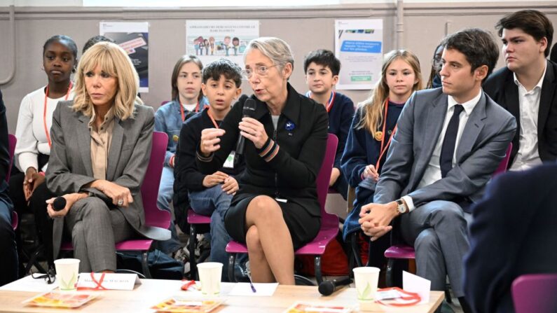 Brigitte Macron (à g.), le ministre de l'Éducation et de la Jeunesse Gabriel Attal (à dr.) et la Première ministre Élisabeth Borne s'adressent aux élèves lors de leur visite dans un collège parisien sur le thème du harcèlement scolaire, le 9 novembre 2023. (Photo BERTRAND GUAY/POOL/AFP via Getty Images)