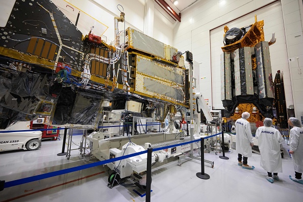 Des employés d'Airbus devant les satellites météorologiques MetOp-SG A (G) et MetOp-SG B (D) MetOp-SG dans la salle blanche de la branche défense et espace de l'entreprise, le 10 novembre 2023 à Toulouse. (Photo LIONEL BONAVENTURE/AFP via Getty Images)