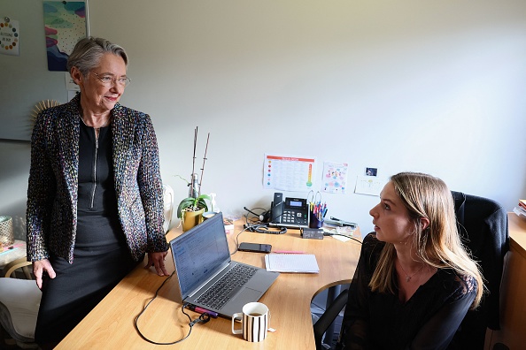 La Première ministre Élisabeth Borne s'entretient avec une psychologue lors de sa visite à l'association d'aide aux enfants victimes « Enfant Bleu » à Issy-les-Moulineaux, le 20 novembre 2023. (Photo ALAIN JOCARD/AFP via Getty Images)