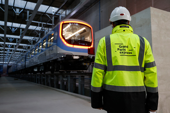 Un ouvrier se tient devant le premier train de la ligne 15, dans le cadre du projet du Grand Paris Express, à la gare de Champigny-sur-Marne, le 28 novembre 2023. (Photo LUDOVIC MARIN/AFP via Getty Images)