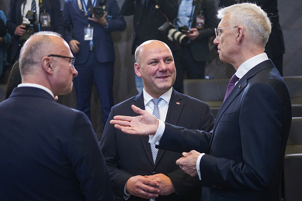 Le ministre polonais des Affaires étrangères, Szymon Andrzej Szynkowski vel Sek (au centre), s'entretient avec le ministre letton des Affaires étrangères, Krisjanis Karins (à droite), avant le début d'une réunion des ministres des Affaires étrangères de l'OTAN au siège de l'OTAN à Bruxelles, le 28 novembre 2023. (Photo : SIMON WOHLFAHRT/AFP via Getty Images)