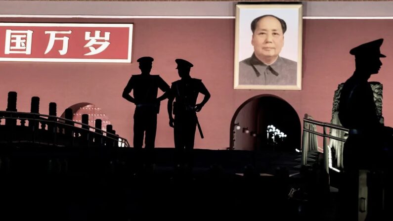 Des policiers paramilitaires chinois montent la garde sous un portrait de Mao Zedong devant la Cité Interdite sur la place Tiananmen, le 4 juin 2014 à Pékin, en Chine. (Photo par Kevin Frayer/Getty Images)