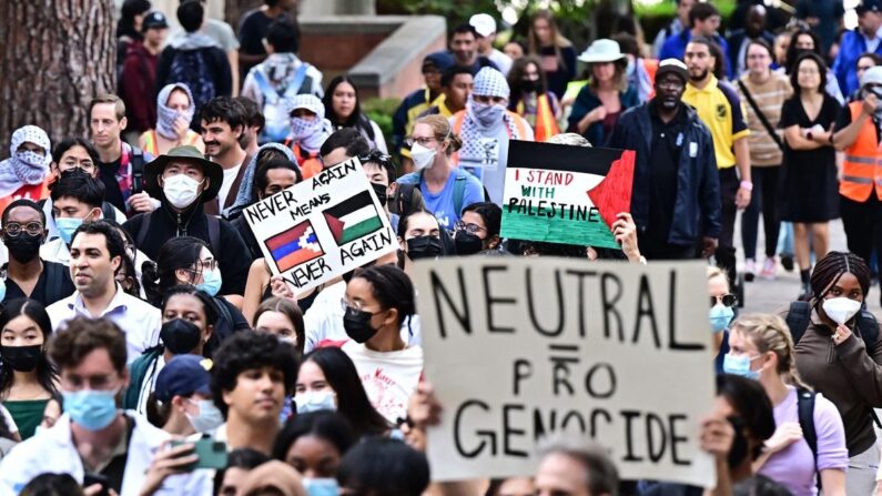 Un manifestant tient une pancarte présentant un drapeau palestinien à côté d'un drapeau de l'Artsakh (nom arménien du Haut-Karabakh) alors que des étudiants participent à un "Walkout pour lutter contre le génocide et libérer la Palestine" sur la Bruin Plaza de l'UCLA, à Los Angeles (Californie), le 25 octobre 2023. (Frederic J. Brown/AFP/Getty Images)