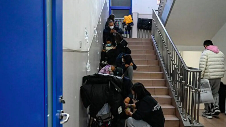 Pose d'une perfusion à des enfants dans les escaliers d'un hôpital pour enfants à Pékin, le 23 novembre 2023. (Jade Gao /AFP via Getty Images)