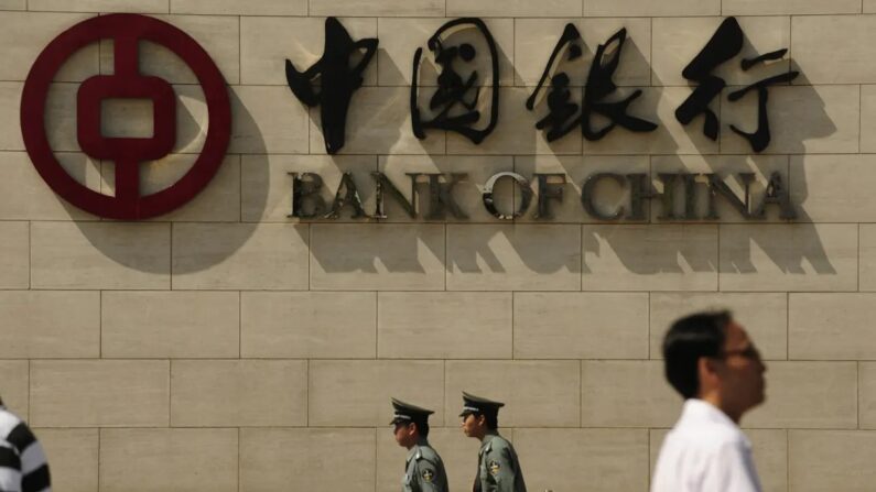 Des personnes passent devant une succursale de la Banque de Chine à Pékin, le 11 septembre 2009. (Peter Parks/AFP via Getty Images)