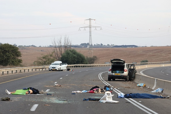  Des corps gisent sur une route principale près du kibboutz Gevim, à proximité de la frontière avec Gaza, le 7 octobre 2023. (Photo OREN ZIV/AFP via Getty Images)